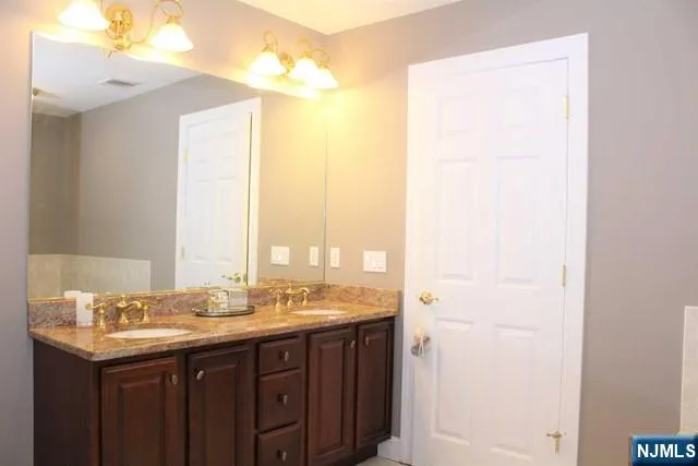 a bathroom with a granite countertop sink and a mirror
