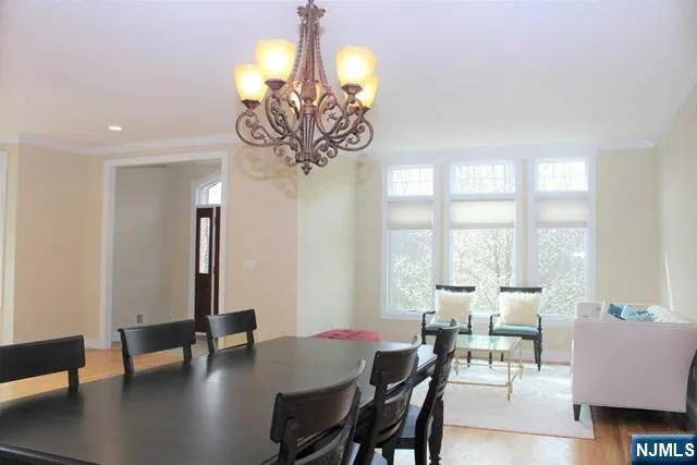 a view of a dining room with furniture wooden floor and chandelier