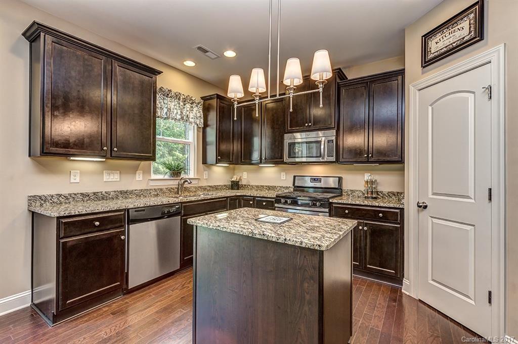 3032 Fallondale Road Waxhaw, NC 28173 - Photo 11 of 23 a kitchen with stainless steel appliances granite countertop hardwood floor sink stove and refrigerator
