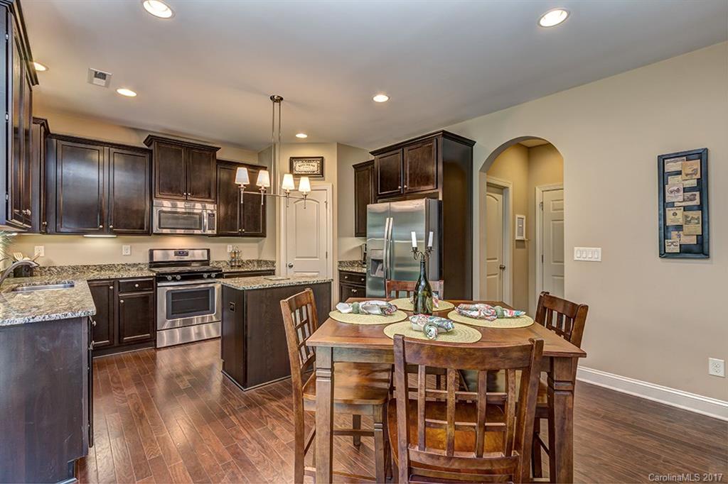 3032 Fallondale Road Waxhaw, NC 28173 - Photo 9 of 23 a kitchen with stainless steel appliances granite countertop a stove a sink dishwasher a refrigerator with a dining table and chairs