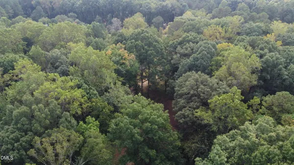 an aerial view of residential house with outdoor space and trees all around