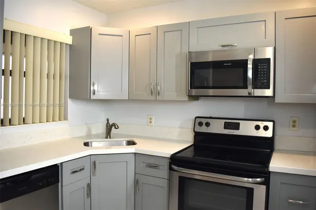 a kitchen with stainless steel appliances white cabinets and a stove top oven