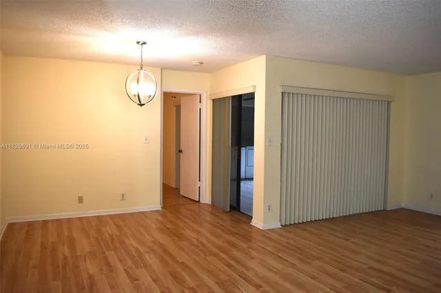 an empty room with wooden floor and ceiling fan