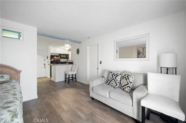 a living room with furniture and a dining table with wooden floor