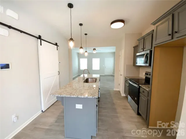 a large kitchen with a refrigerator a sink and dishwasher