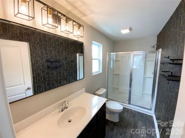 a bathroom with a sink a toilet and shower