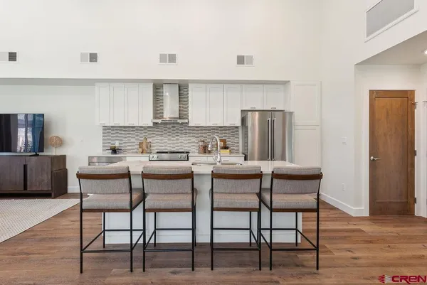 a kitchen with a table chairs refrigerator and cabinets