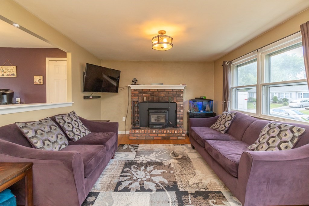 206 Pine Acre Road Springfield, MA 01129 - Photo 5 of 25 a living room with furniture a flat screen tv and a fireplace