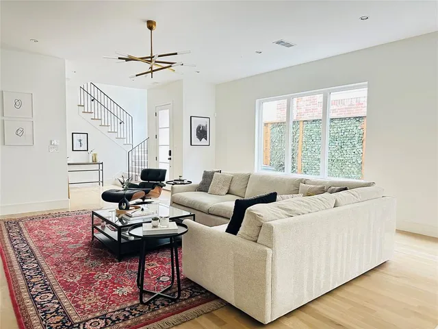 a white kitchen with stainless steel appliances a stove a sink a refrigerator a center island and furniture