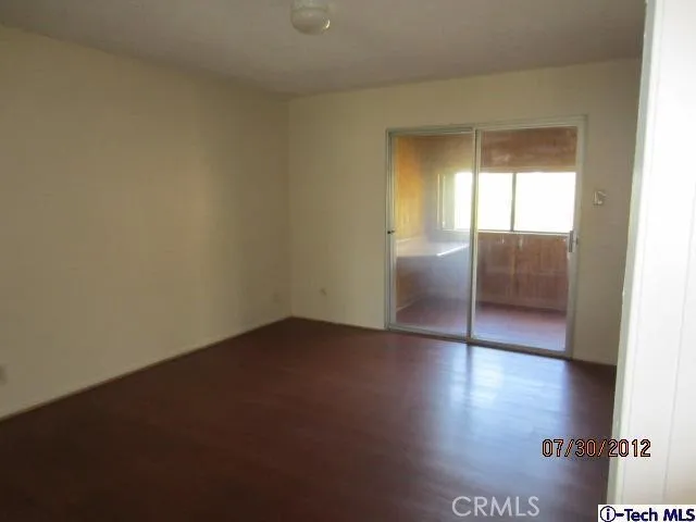 an empty room with wooden floor and door