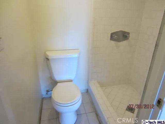 a white toilet sitting next to a shower