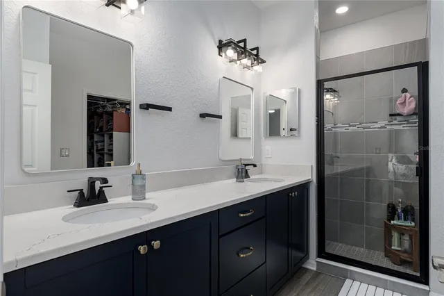 a bathroom with a double vanity sink mirror and shower