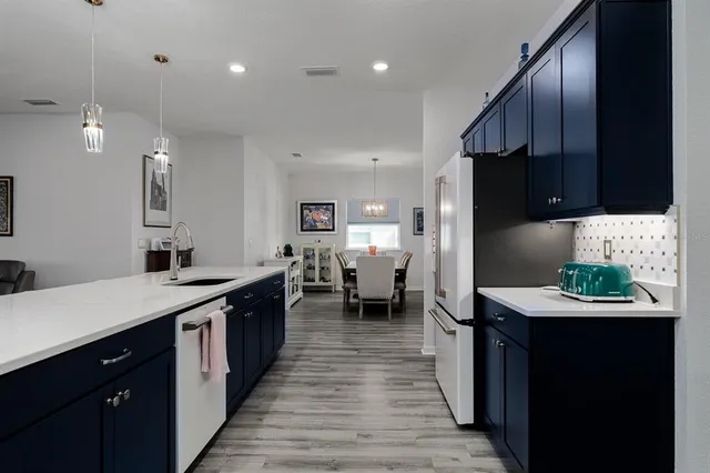 a kitchen with stainless steel appliances kitchen island granite countertop a sink a stove and a refrigerator