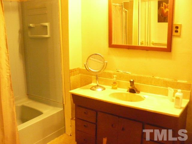 1311 Bethel Road Raleigh, NC 27610 - Photo 23 of 24 a bathroom with a tub sink and mirror