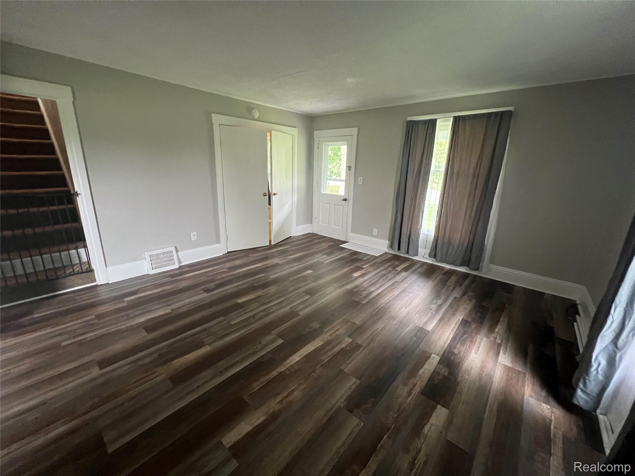 7250 Angle Road Northville, MI 48168 - Photo 7 of 21 Wood-finish flooring throughout, white trim, and a paneled white door
