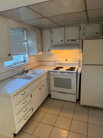 a kitchen with cabinets stainless steel appliances and sink
