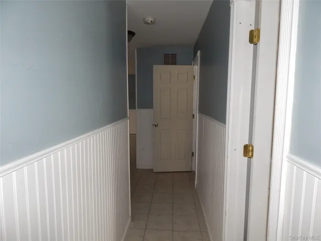 a view of a hallway with wooden cabinets