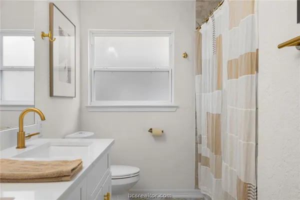 a bathroom with a sink toilet and shower