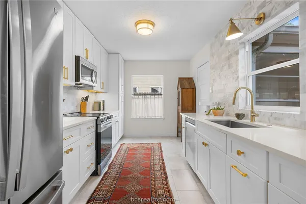 a kitchen with cabinets oven and a sink