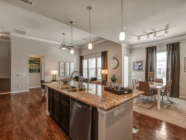 a kitchen with granite countertop a sink a counter space appliances and cabinets