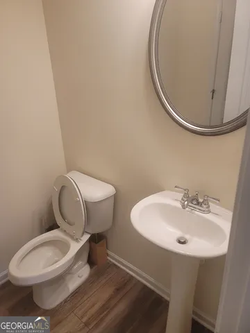 a bathroom with a toilet a sink and mirror