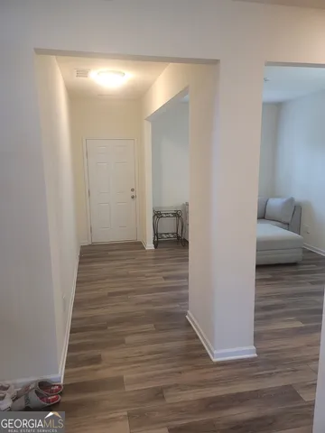 a view of a room with wooden floor and furniture