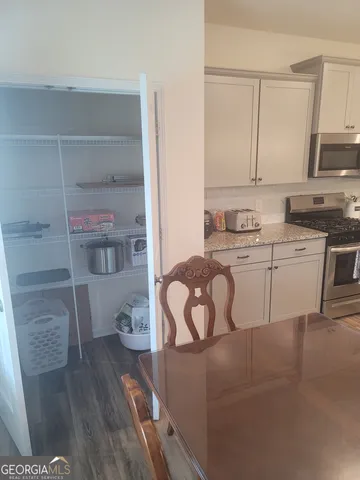 a kitchen with a sink a stove cabinets and wooden floor