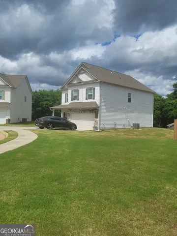a front view of a house with a garden and yard