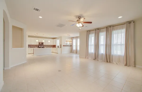 a view of a livingroom with furniture wooden floor fan and windows