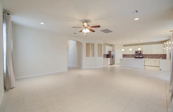 a view of an empty room with a ceiling fan