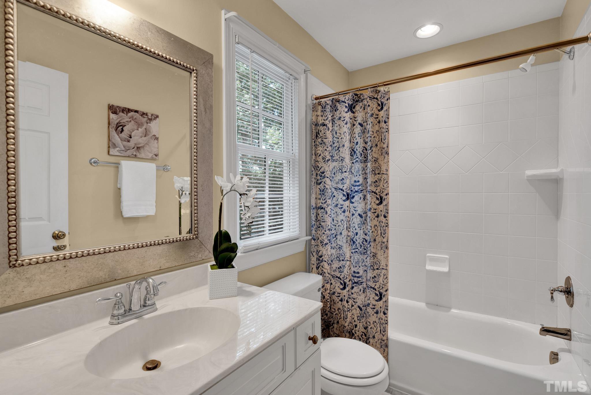 1012 Tyrrell Road Raleigh, NC 27609 - Photo 12 of 24 a bathroom with a bathtub shower sink vanity and toilet