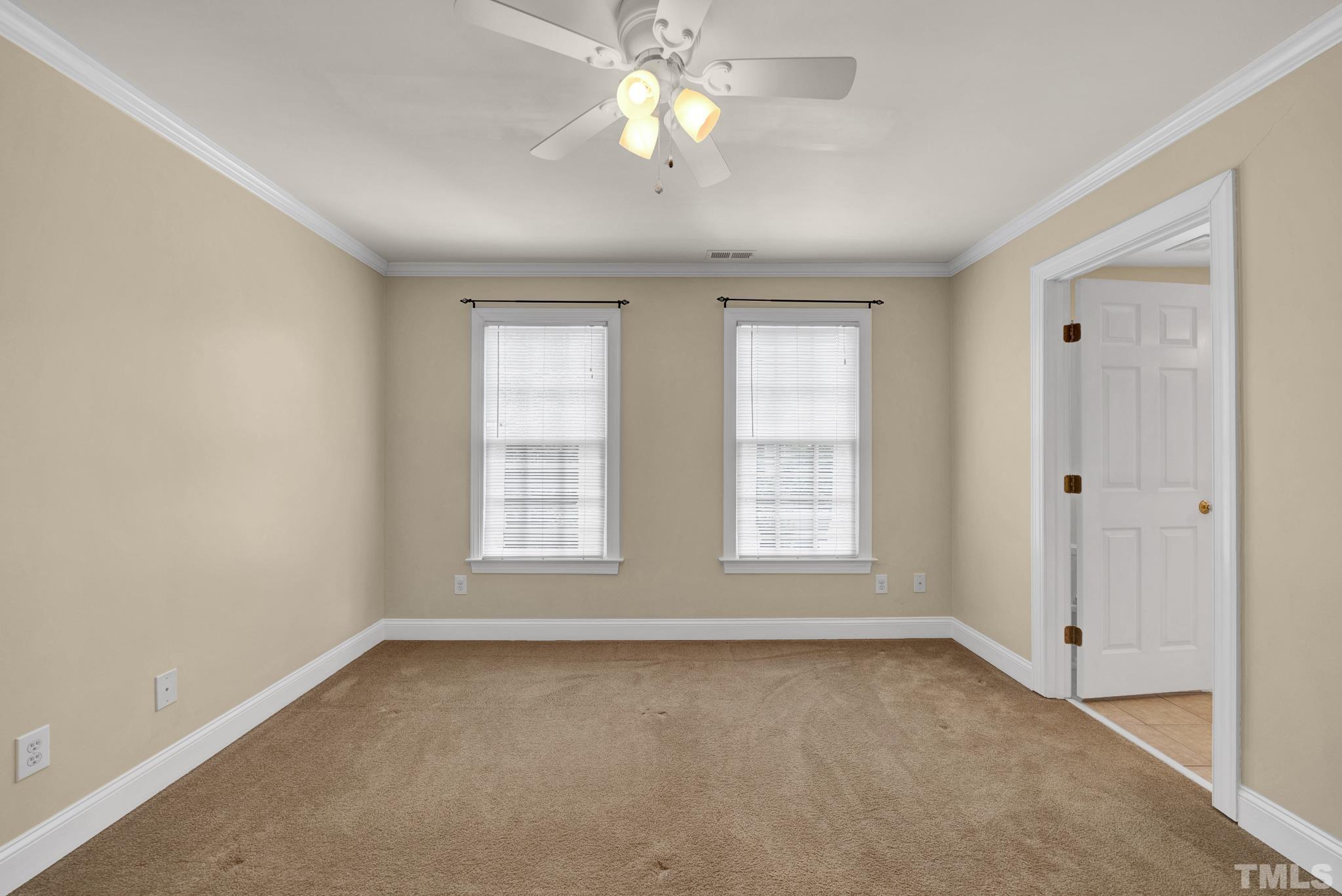 1012 Tyrrell Road Raleigh, NC 27609 - Photo 15 of 24 an empty room with chandelier fan and windows