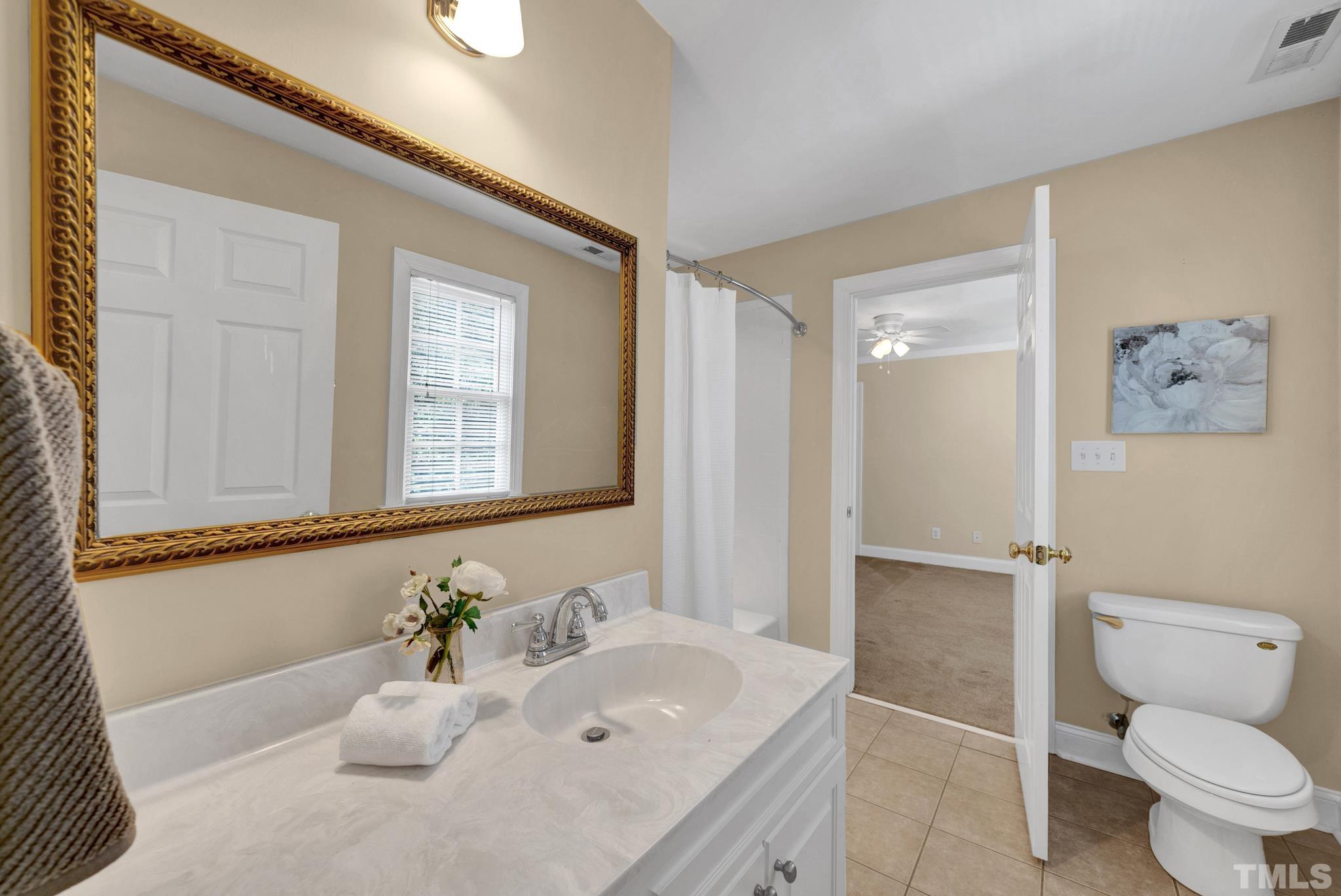 1012 Tyrrell Road Raleigh, NC 27609 - Photo 17 of 24 a bathroom with a sink mirror vanity and toilet