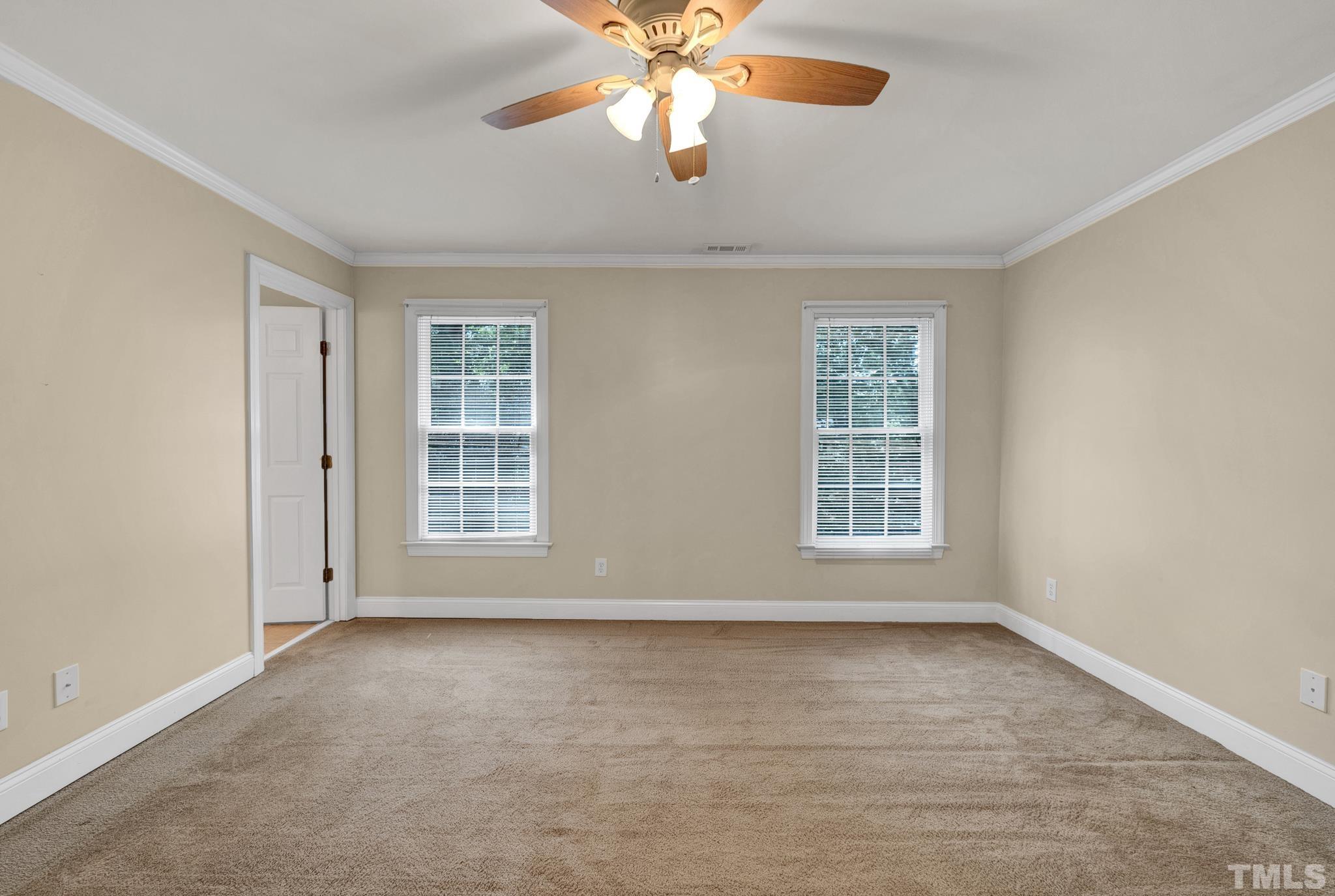 1012 Tyrrell Road Raleigh, NC 27609 - Photo 22 of 24 an empty room with chandelier fan and windows