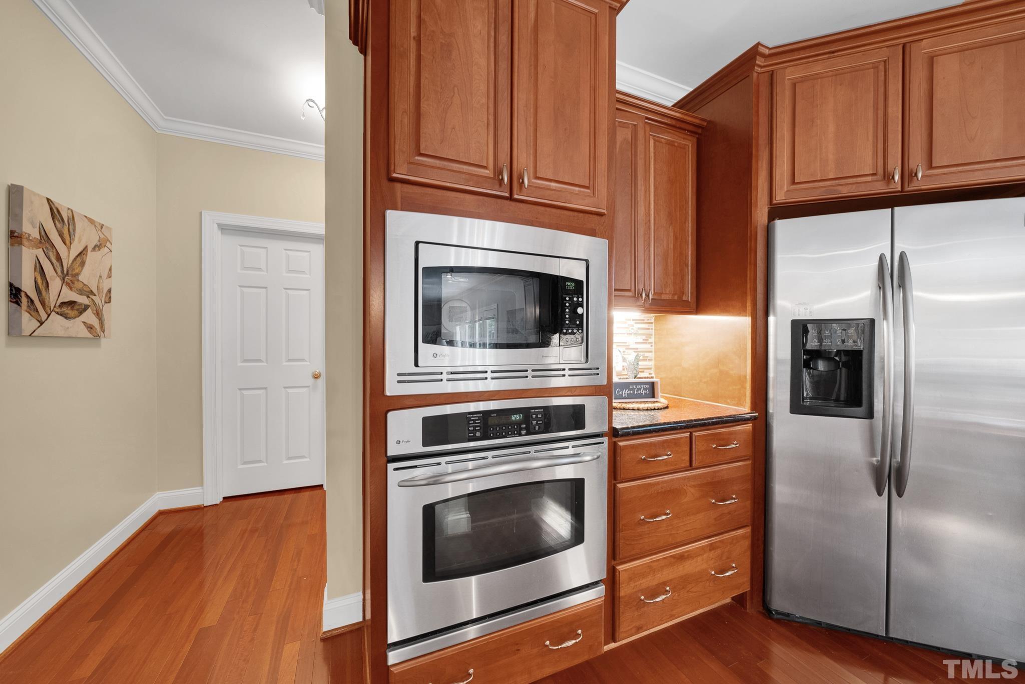 1012 Tyrrell Road Raleigh, NC 27609 - Photo 7 of 24 a kitchen with granite countertop wooden cabinets and stainless steel appliances