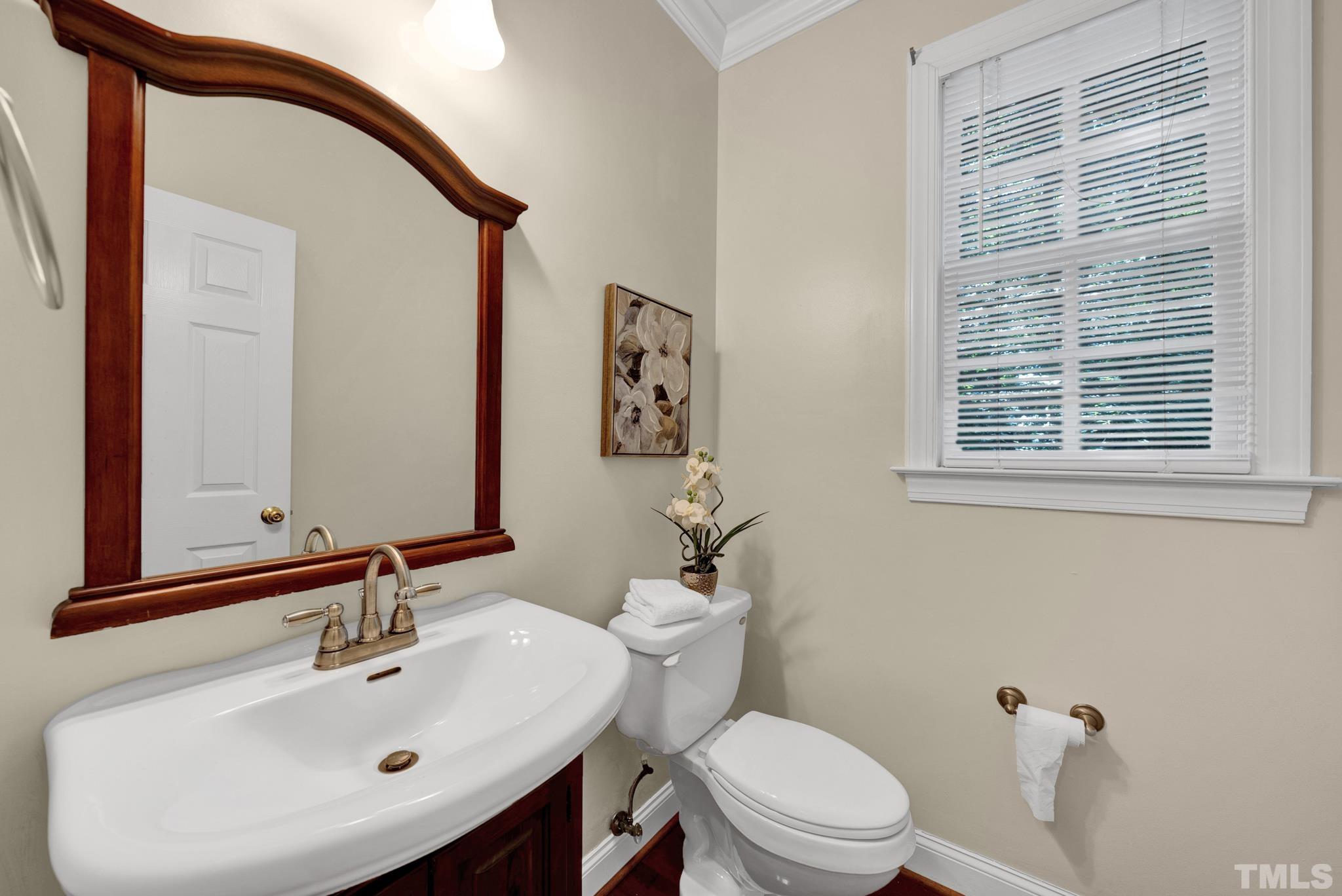 1012 Tyrrell Road Raleigh, NC 27609 - Photo 10 of 24 a bathroom with a sink a mirror and a toilet