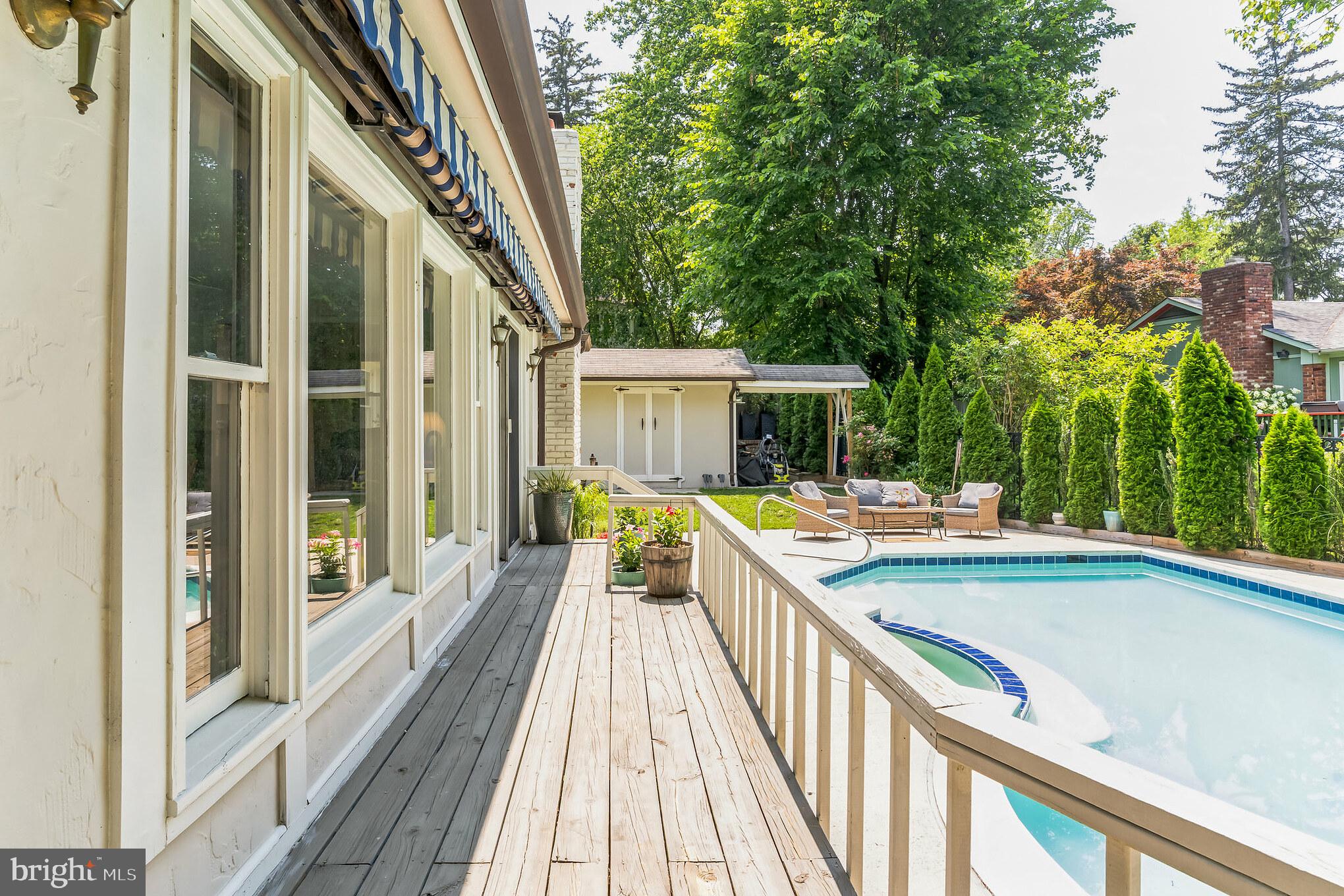 9329 Harvey Road Silver Spring, MD 20910 - Photo 31 of 40 a view of balcony with a swimming pool and wooden seating