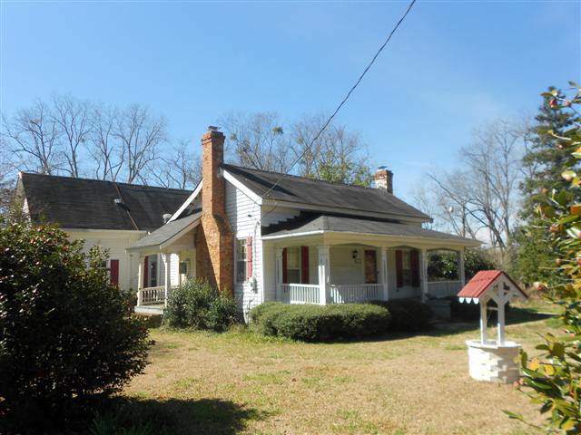 a front view of a house with a yard and potted plants
