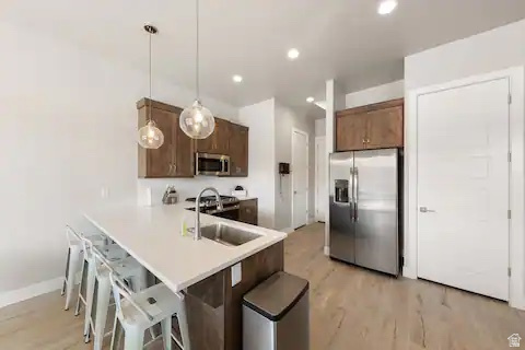 2600 Ocotillo Way, Unit 56 Santa Clara, UT 84765 - Photo 4 of 33 Kitchen with a kitchen bar, stainless steel appliances, pendant lighting, light countertops, and a peninsula