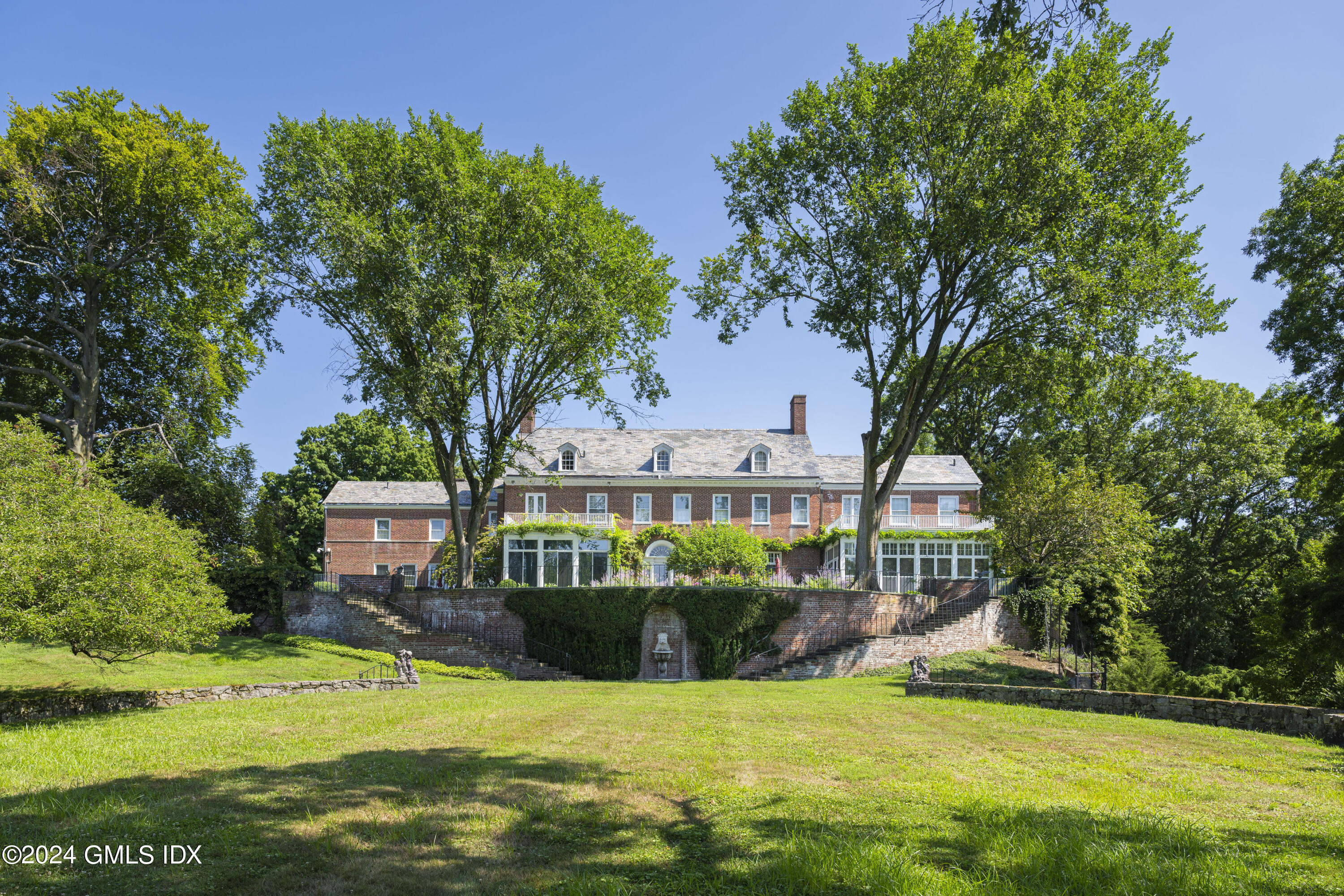 10 Cliffdale Road Greenwich, CT 06831 - Photo 24 of 31 a view of a house with a big yard and potted plants and large trees