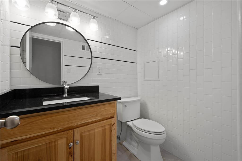 410 Abbeyville Road, Unit D Pittsburgh, PA 15228 - Photo 14 of 19 a bathroom with a granite countertop sink mirror vanity and toilet
