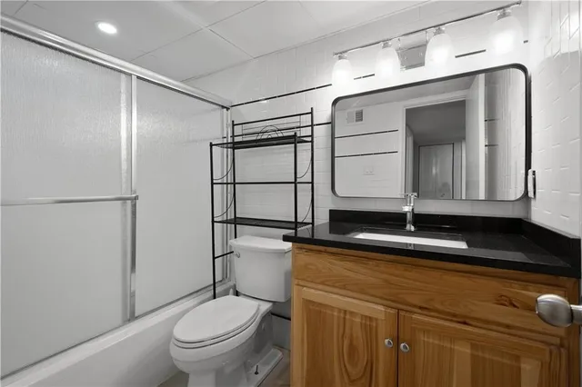 a bathroom with a toilet a sink and mirror