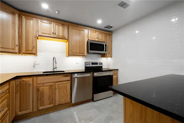 a kitchen with granite countertop sink cabinets and stainless steel appliances