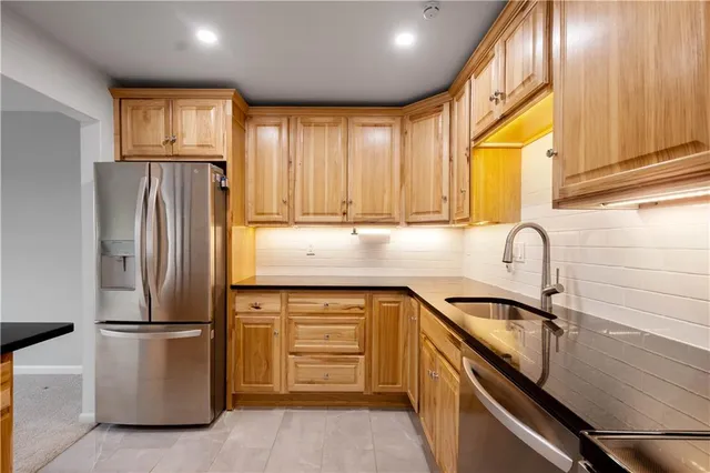a kitchen with granite countertop a refrigerator and a sink