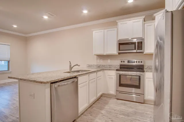 a kitchen with stainless steel appliances granite countertop a refrigerator and a sink