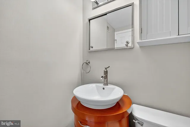a bathroom with a toilet a sink and mirror