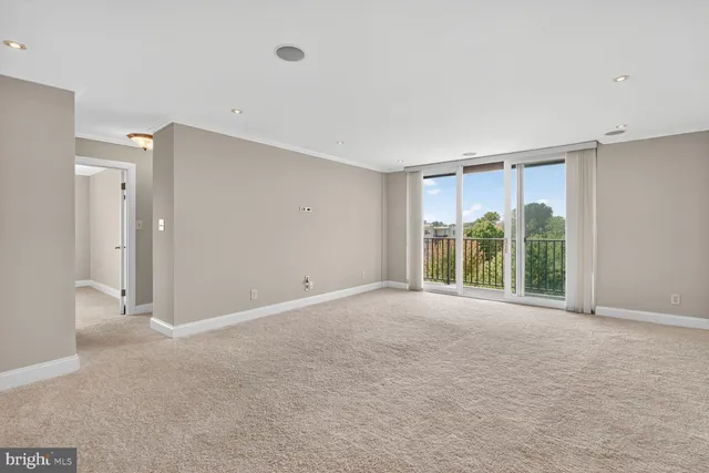 a view of an empty room with glass door and balcony