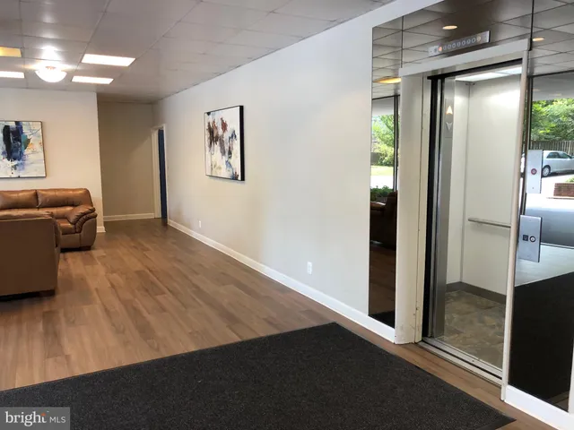 a room with a wooden floor and potted plant