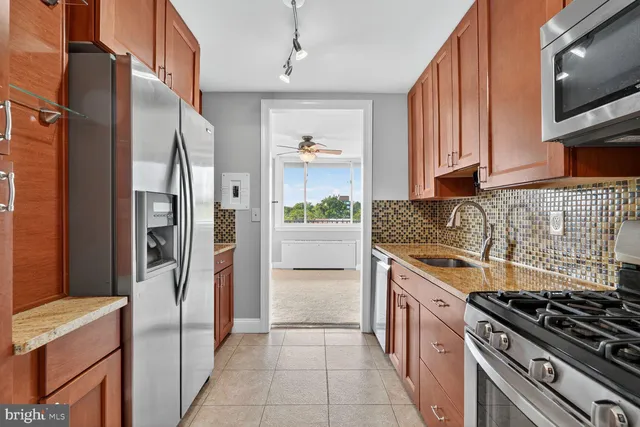a kitchen with stainless steel appliances granite countertop a refrigerator and a stove