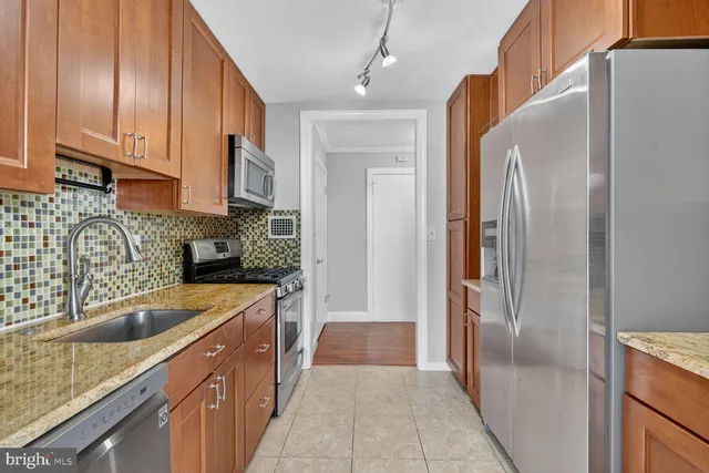 a kitchen with stainless steel appliances granite countertop a refrigerator and a sink